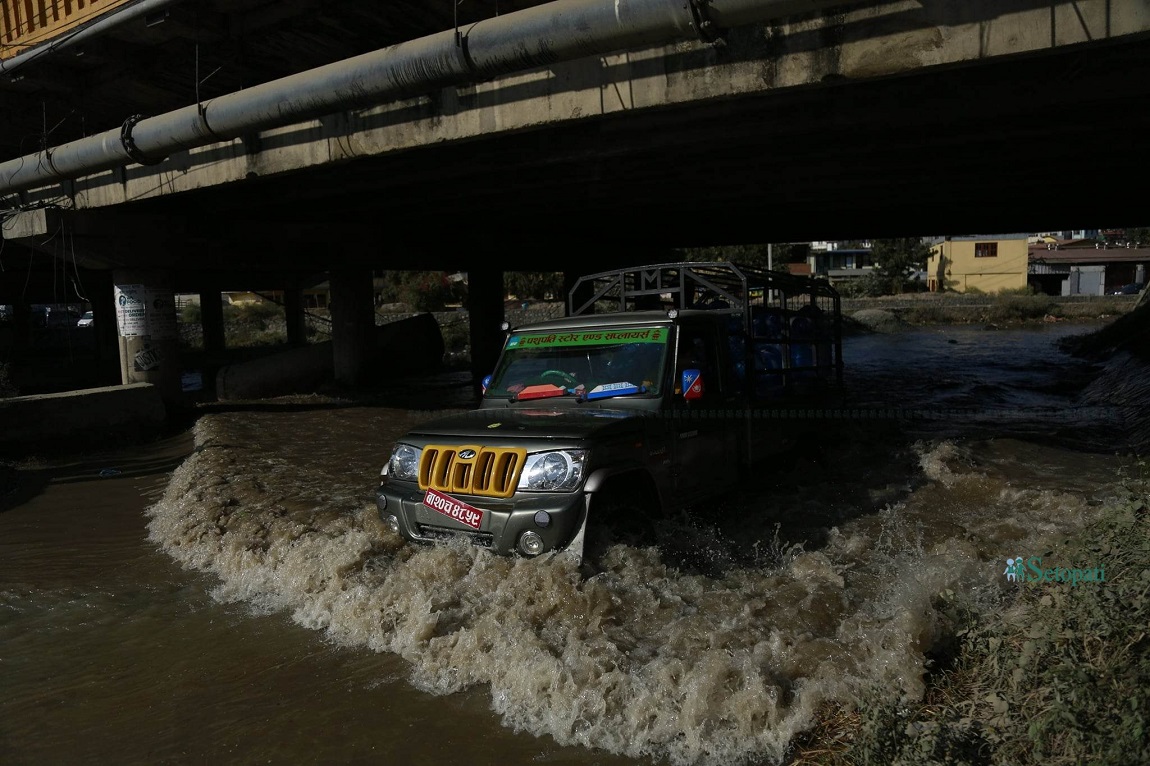 काठमाडौंको तीनकुनेस्थित सडकमा पानी भरिएपछि सवारी साधन आवागमनमा समस्या भएको छ। मेलम्ची खानेपानी आयोजनाको पाइपमा पानी पठाएर परीक्षण गर्ने क्रममा सडकमा पानी जम्मा भएको हो। तस्बिर: नवीनबाबु गुरूङ