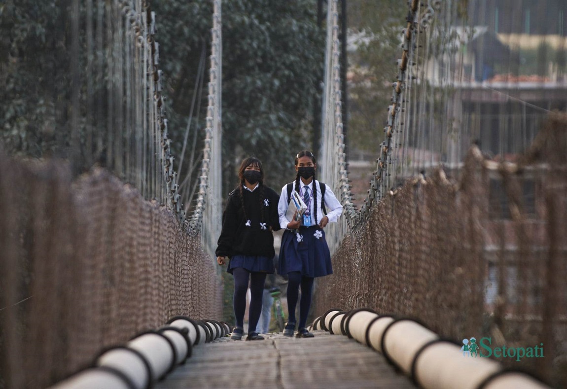 कीर्तिपुरस्थित झुलुंगे पुल तर्दै गरेका विद्यार्थी। तस्वीर: नवीनबाबु गुरूङ/सेतोपाटी