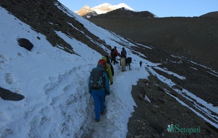 थोराङपास गर्नेक्रममा हाइक्याम्पबाट उकालो चढ्दै गरेका पर्यटकहरू। तस्बिरः रमेश