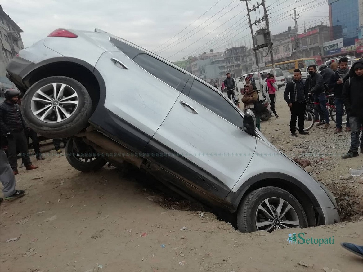 गोंगबुमा सडक बिभागले त्यसै छोडेको खाल्डोमा परेको गाडी। तस्बिरः सुनिता  सिटौला