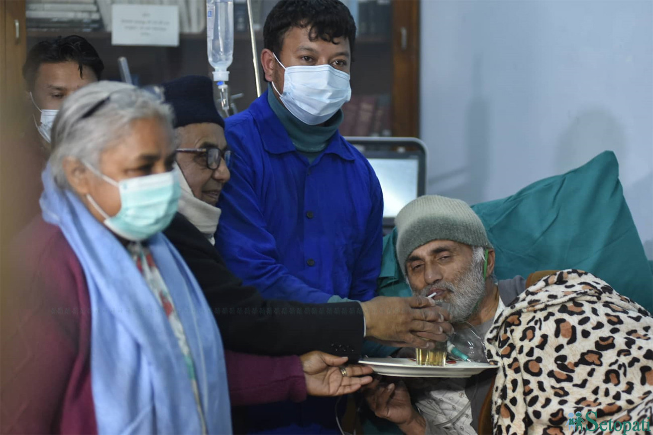 शिक्षण अस्पतालका सफाइ कर्मचारी, पूर्व प्रधानन्यायधीशको हातबाट  जुस पिएर अनसन तोड्दै डा. केसी।  तस्बिरः नारायण महर्जन