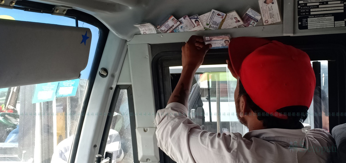 सहचालकले जफत गरेका नक्कली विद्यार्थी कार्ड मिलाउँदै एक सार्वजनिक बसका चालक। तस्बिर :   प्रशन्न पोखरेल/ सेतोपाटी