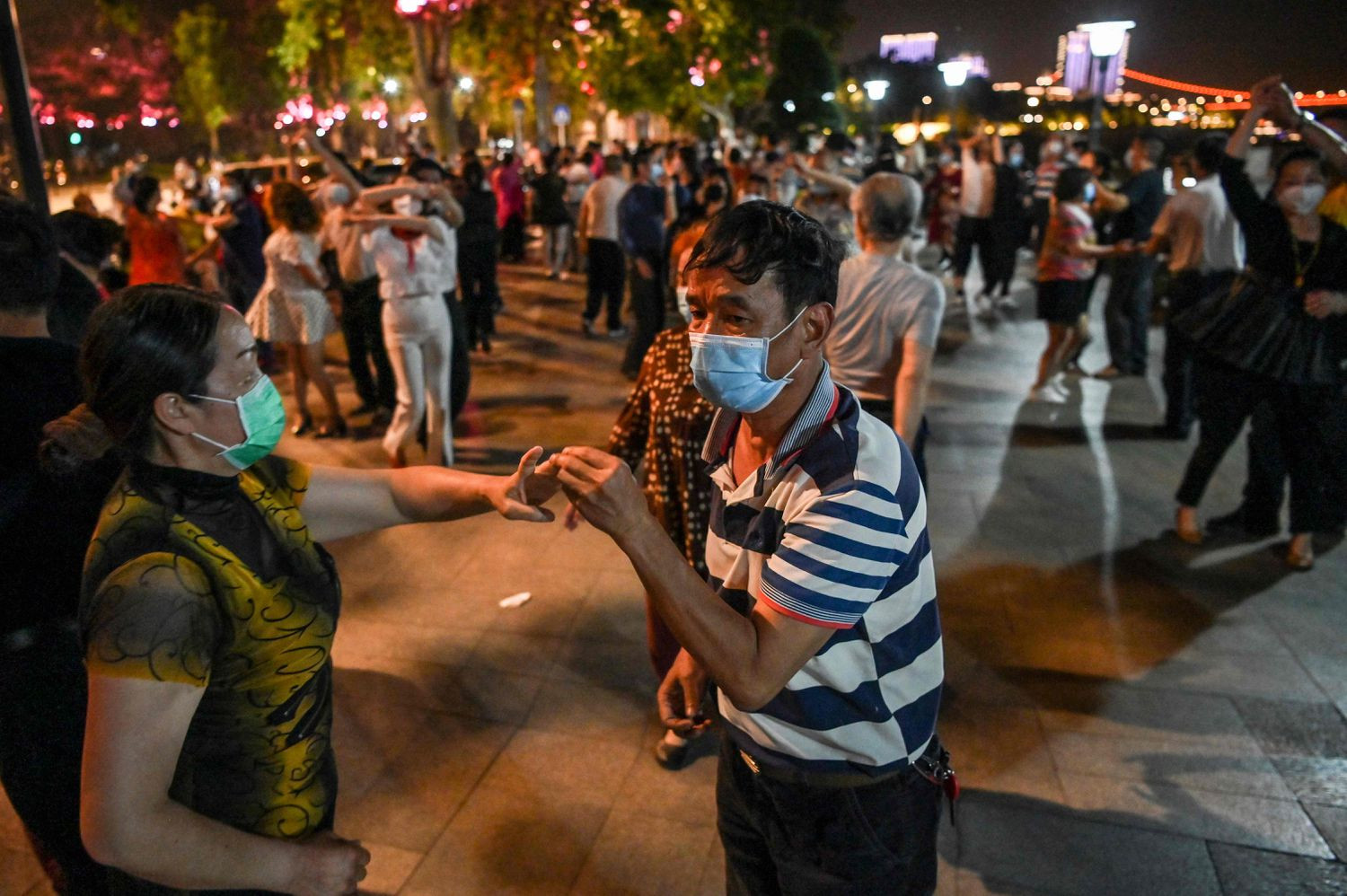 चीनको वुहानस्थित याङ्जी नदी किनारमा मास्क लगाएर डान्स पार्टी गरिँदै। तस्बिर: वासिङ्टन पोस्ट