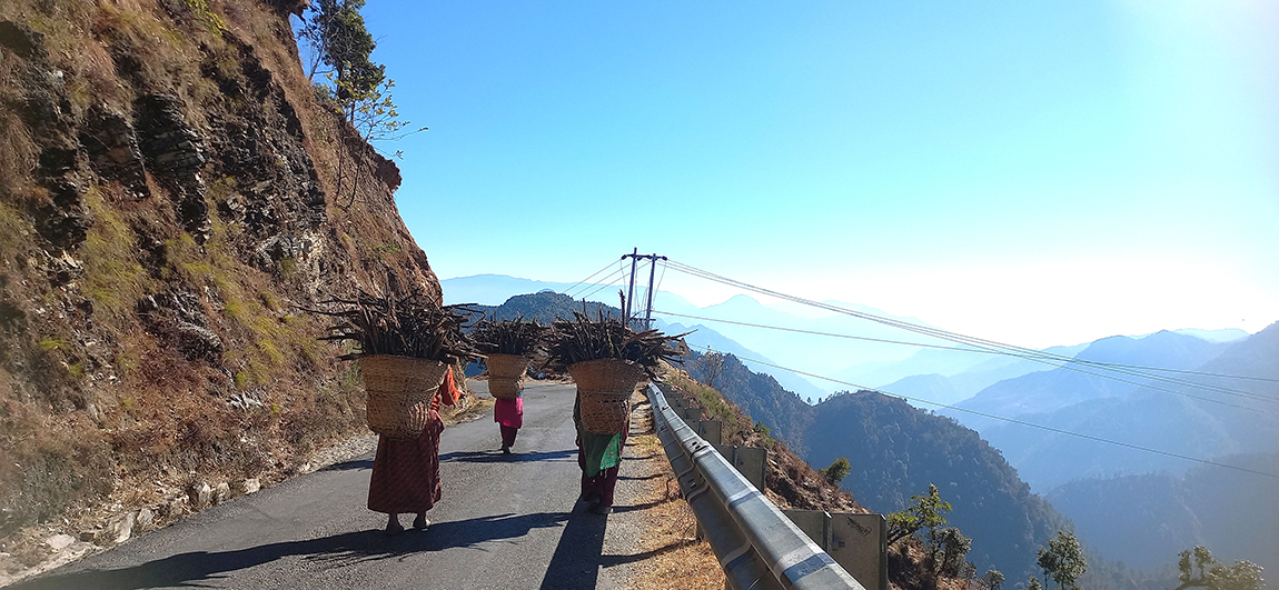बैतडीको सिगास गाउँपालिका-९ का महिला नजिकैको वनबाट दाउराको भारी बोकेर घरतर्फ फर्कँदै। ग्रामीण क्षेत्रका बासिन्दा घरायसी इन्धनका रूपमा दाउराको समेत प्रयोग गर्दै आएका छन्। तस्बिर- डम्बर बोहरा/रासस