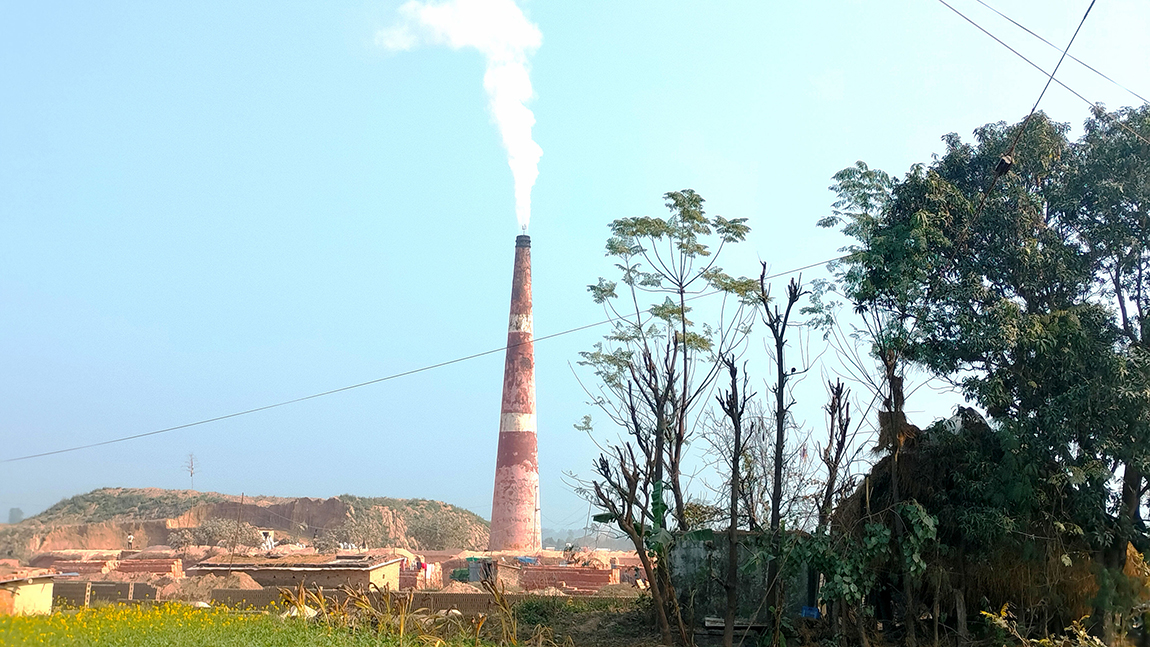 कञ्चनपुरको शुक्लाफाँटा नगरपालिका-११ कलुवापुरमा रहेको इँटाभट्टाको चिम्नीबाट निस्कँदै गरेको धुवाँको मुश्लो।  इँटाभट्टा राखिएपछि बस्तीमा वायु  प्रदूषणको जोखिम बढेकाे छ। तस्बिर: राजेन्द्रप्रसाद पनेरू/रासस