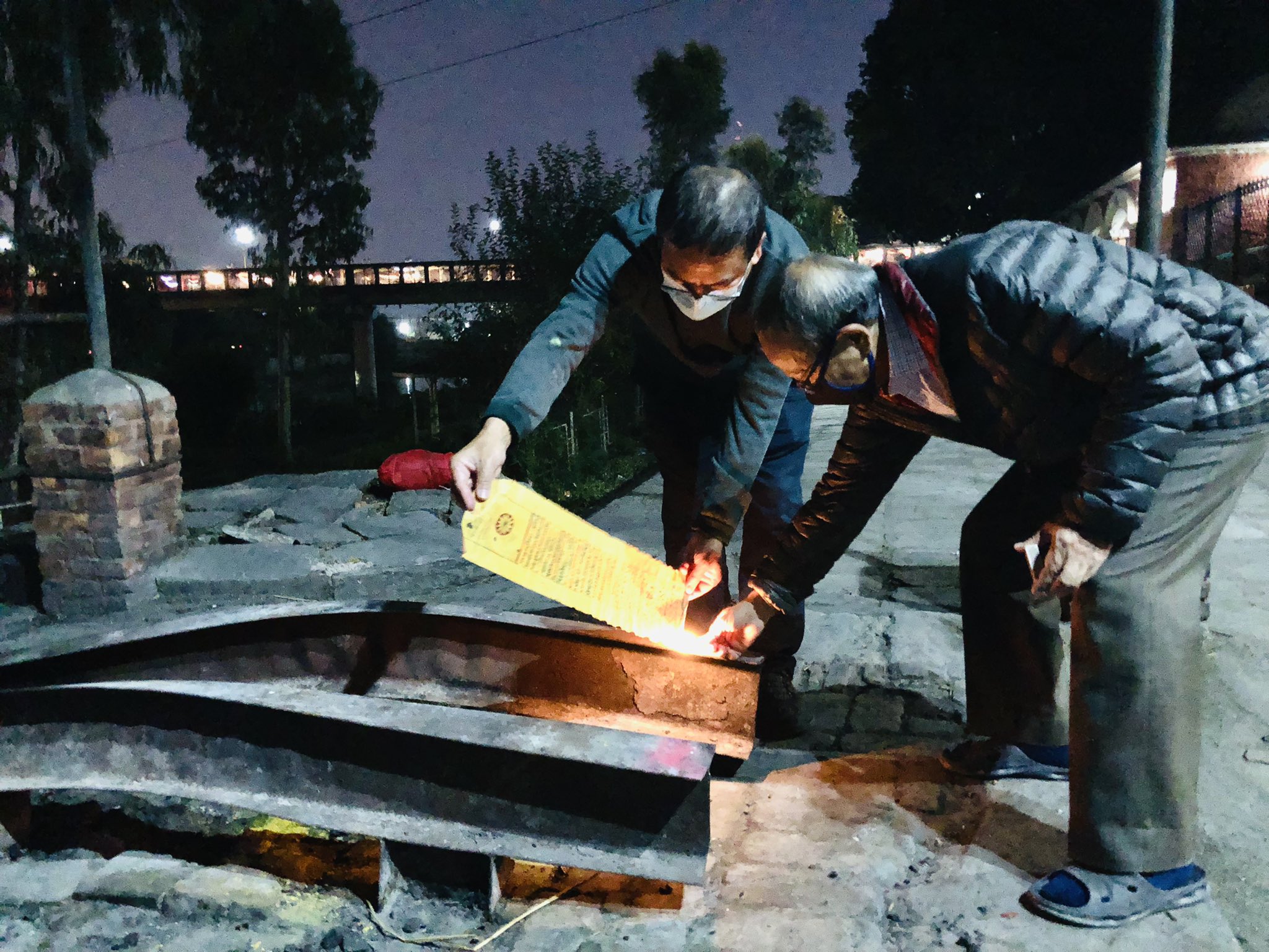 पिताको इच्छाबमोजिम शरीर अस्पताललाई दान दिएपछि सत्यमोहन जोशीको जन्मकुण्डली शंखमूलस्थित बागमती घाटमा बेलुकी ६.१४ बजे जलाउॅदै जेठा छोरा अनुराज र कान्छा छोरा डा. पूर्णराज जोशी। तस्बिर स्रोत: गिरीश गिरीको ट्विटरबाट