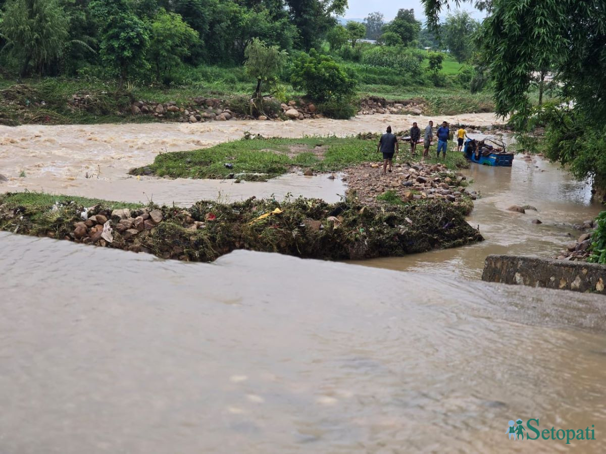 काला खोलामा आएको बाढीले बगाएको अटो।
