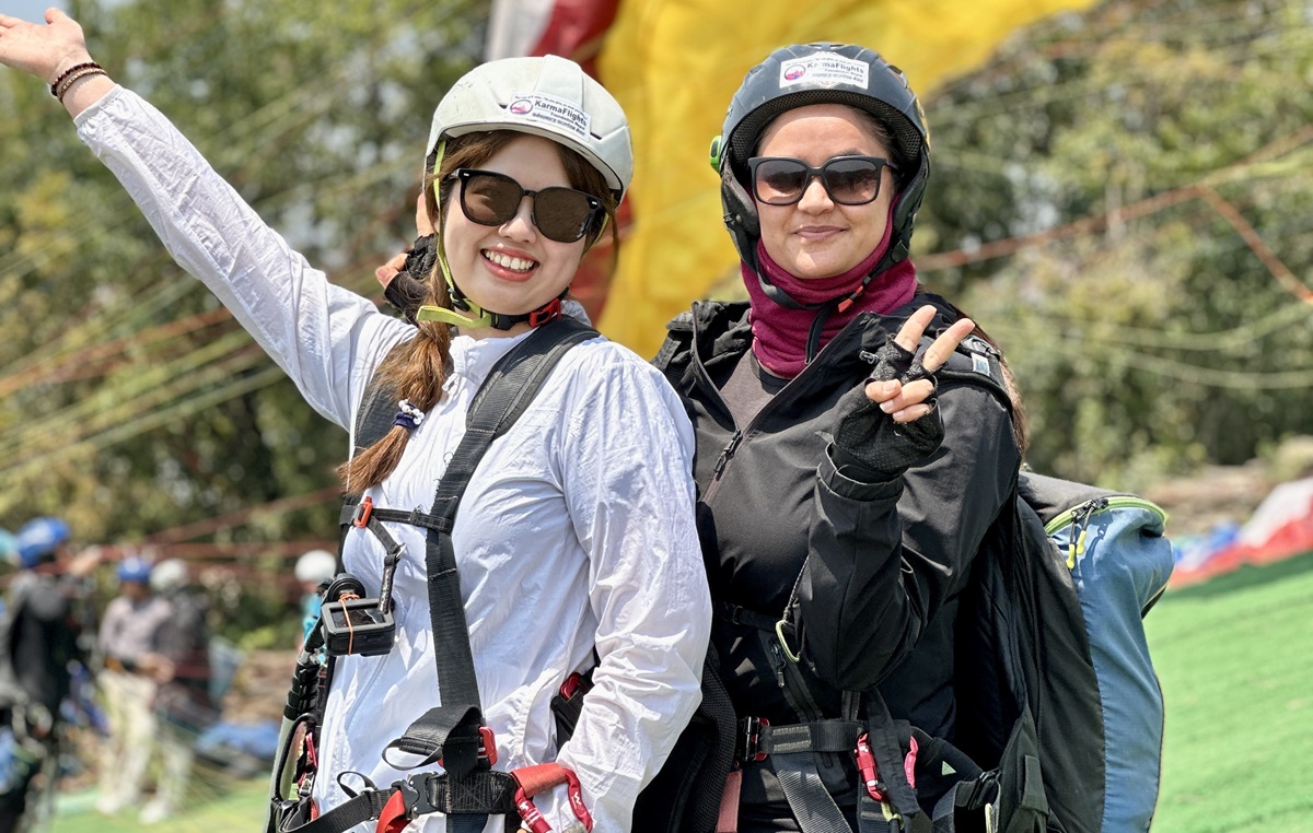 प्याराग्लाइडिङ यात्रुसँग शर्मिला शर्मा (दायाँ)। तस्बिर स्रोतः शर्मिला शर्मा